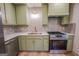 Bright kitchen featuring stainless steel appliances, light green cabinets, and quartz countertops at 5582 Rockingwood Ct, Atlanta, GA 30349