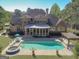 Aerial view of a backyard with a stunning pool, jacuzzi, and outdoor seating of the beautiful brick home at 310 Westbourne Dr, Tyrone, GA 30290