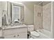Well lit bathroom with a granite countertop vanity, a bathtub and shower, and a large mirror at 310 Westbourne Dr, Tyrone, GA 30290