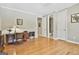 Bedroom featuring hardwood floors, a desk, and an open door to the bathroom at 310 Westbourne Dr, Tyrone, GA 30290
