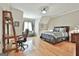 Bright bedroom with hardwood floors has a large bed, desk, a comfy settee and a window at 310 Westbourne Dr, Tyrone, GA 30290