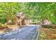 View of the gated entrance into the property from the street, surrounded by luscious green trees at 310 Westbourne Dr, Tyrone, GA 30290