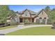 Charming brick home with a lush green lawn and beautifully landscaped front yard at 310 Westbourne Dr, Tyrone, GA 30290