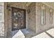 Close-up of the front door with an ornate wrought-iron decoration, set in a traditional brick facade at 310 Westbourne Dr, Tyrone, GA 30290