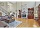 Spacious living room boasting a stone fireplace, hardwood floors, and custom built-in bookshelves at 310 Westbourne Dr, Tyrone, GA 30290