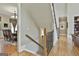 Staircase with wooden handrail, iron spindles, and views into the dining room and hallway at 310 Westbourne Dr, Tyrone, GA 30290