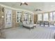The sunroom features brick walls, ceiling fans, and comfortable lounge seating for relaxing indoors at 310 Westbourne Dr, Tyrone, GA 30290