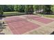 Aerial view of community tennis courts; two courts are red with dark green perimeter fencing at 310 Westbourne Dr, Tyrone, GA 30290