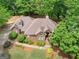 Aerial view of a brick home with a landscaped yard and mature trees at 1466 Lake Forest Ln, Mcdonough, GA 30253