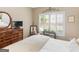 Comfortable bedroom featuring natural light, a four poster bed, and dresser with round mirror at 1466 Lake Forest Ln, Mcdonough, GA 30253