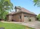 Brick home exterior featuring a three-car garage and well-maintained landscaping at 1466 Lake Forest Ln, Mcdonough, GA 30253