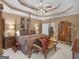 Spacious primary bedroom with tray ceiling, ceiling fan, and sitting area with wood bench at 1466 Lake Forest Ln, Mcdonough, GA 30253