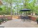 Outdoor patio with brick surround and a dining area under mature trees at 1466 Lake Forest Ln, Mcdonough, GA 30253