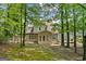 Charming home featuring an outdoor patio, screened-in porch, and a lush backyard surrounded by mature trees at 7020 Grand View Way, Suwanee, GA 30024