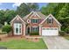 Charming two-story brick home with well-manicured lawn and a two-car garage in a lush, green neighborhood at 7020 Grand View Way, Suwanee, GA 30024