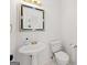 Elegant half bathroom featuring a pedestal sink, decorative mirror, and classic fixtures at 7020 Grand View Way, Suwanee, GA 30024