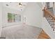 Bright living room with large windows, ceiling fan, and staircase with wooden banister at 7020 Grand View Way, Suwanee, GA 30024