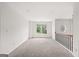 Bright loft area with neutral carpet, large window, and railing at 7020 Grand View Way, Suwanee, GA 30024