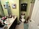 Bathroom with green walls, linoleum flooring, dark vanity and matching wall cabinet at 177 Villa Rosa Way, Temple, GA 30179