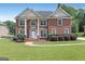 Elegant red brick home with a manicured lawn and stately white pillars at the front entry at 3183 Jackson Creek Dr, Stockbridge, GA 30281