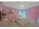 Pink bedroom with a ceiling fan, decorated walls, and a full-sized bed with side tables at 6697 Princeton Park Walk, Lithonia, GA 30058