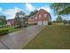 Spacious driveway leading to a brick home with a well-manicured lawn and garden beds at 6697 Princeton Park Walk, Lithonia, GA 30058