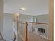 Upstairs hallway overlooking the living room features wood railing and carpeted floor at 6697 Princeton Park Walk, Lithonia, GA 30058