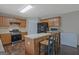 Kitchen with wood cabinets, an island with seating, a stove, and a refrigerator at 6697 Princeton Park Walk, Lithonia, GA 30058
