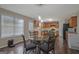 Bright eat-in kitchen features wood cabinets, a glass table with seating, and modern lighting fixtures at 6697 Princeton Park Walk, Lithonia, GA 30058