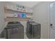 Laundry room with updated washer and dryer and storage shelves at 6697 Princeton Park Walk, Lithonia, GA 30058