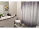 Clean bathroom with single vanity, tile floors, toilet, and a shower with patterned curtain at 8045 Coleson Xing, Locust Grove, GA 30248