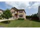 Lovely two-story home with well-manicured lawn, complemented by a young tree and lush green grass at 8045 Coleson Xing, Locust Grove, GA 30248