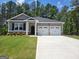 Beautifully landscaped front yard of a charming, gray, single-story home with a two-car garage at 346 Friendship Oak Way, Hampton, GA 30228