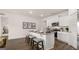 Open-concept kitchen with granite island, stainless steel appliances, white cabinets and modern stools at 346 Friendship Oak Way, Hampton, GA 30228