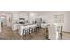 Open-concept kitchen with stainless appliances, white cabinets, granite counters, island seating, and dining area at 346 Friendship Oak Way, Hampton, GA 30228