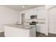 Modern kitchen boasts white cabinets, granite countertops, an island, and stainless steel appliances at 346 Friendship Oak Way, Hampton, GA 30228