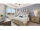Serene main bedroom with soft blue accents, plush bedding, and ample natural light through a large window at 346 Friendship Oak Way, Hampton, GA 30228