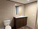 Clean bathroom showing a vanity with stone countertop and a toilet at 30 Alyssa Ln, Bowdon, GA 30108