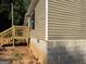 Side view of home showing siding, foundation, and wooden steps at 30 Alyssa Ln, Bowdon, GA 30108