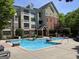 Exterior shot of a building with a community pool, lounge furniture, and landscaped greenery at 3108 Westchester Ne Rdg, Atlanta, GA 30329