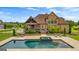 Beautiful backyard featuring a swimming pool and a large brick home at 770 Tralee Dr, Fayetteville, GA 30215