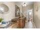 Bathroom featuring a wooden vanity with a granite countertop, decorative mirrors, and neutral-toned tile flooring at 770 Tralee Dr, Fayetteville, GA 30215