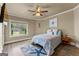Bedroom with a light blue color scheme, ceiling fan and a window overlooking the backyard at 770 Tralee Dr, Fayetteville, GA 30215