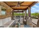 Relaxing covered patio featuring wood ceiling, outdoor furniture, and view of the lush backyard at 770 Tralee Dr, Fayetteville, GA 30215