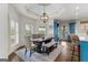 Dining room with large window, modern chandelier, and wood table with seating at 770 Tralee Dr, Fayetteville, GA 30215
