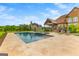 A beautiful home with a backyard pool, travertine deck, patio, and lush landscaping provides an ideal outdoor living space at 770 Tralee Dr, Fayetteville, GA 30215