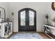 Arched front door with iron detailing, decorative rug, hardwood floors and ornate wall decor at 770 Tralee Dr, Fayetteville, GA 30215