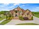 Stunning brick home featuring a manicured lawn, beautiful landscaping, and an arched stone entryway at 770 Tralee Dr, Fayetteville, GA 30215