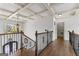 Upstairs hallway features coffered ceilings, hardwood floors, and decorative iron railings at 770 Tralee Dr, Fayetteville, GA 30215