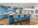 Kitchen island with marble countertop, blue cabinets, and woven barstools at 770 Tralee Dr, Fayetteville, GA 30215